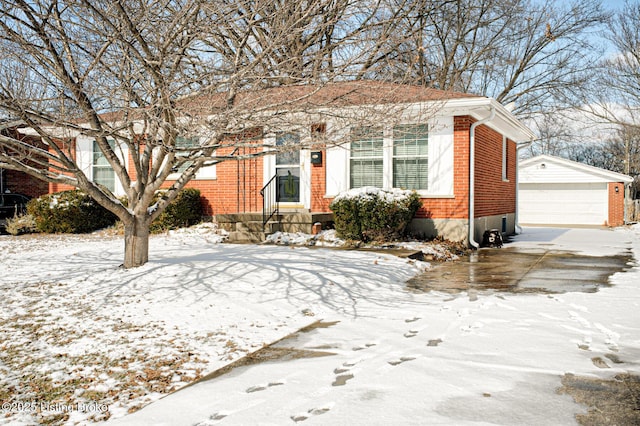 view of front of house featuring a detached garage, an outdoor structure, and brick siding