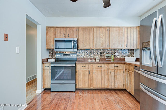 kitchen with stainless steel appliances, visible vents, backsplash, a ceiling fan, and light wood-type flooring