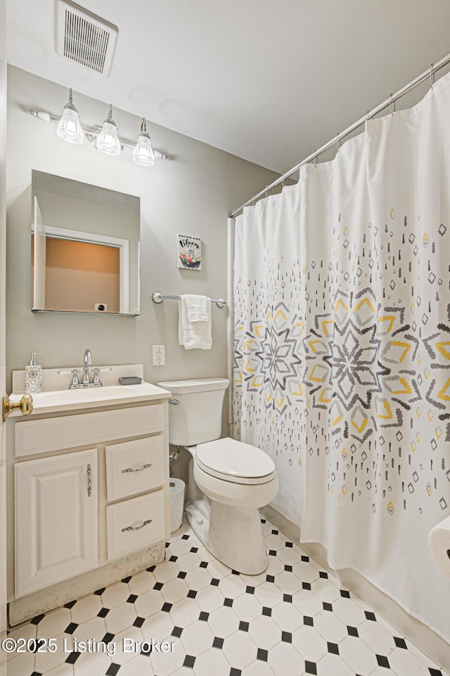 bathroom featuring visible vents, a shower with shower curtain, toilet, tile patterned floors, and vanity