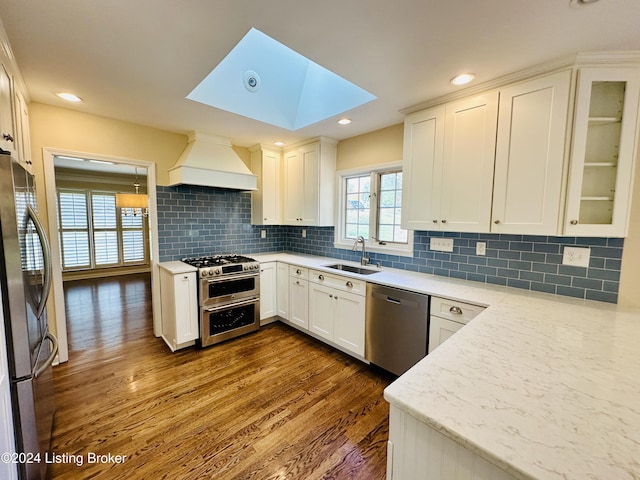 kitchen featuring white cabinetry, sink, stainless steel appliances, dark hardwood / wood-style flooring, and custom range hood