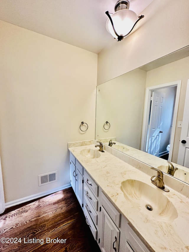 bathroom featuring hardwood / wood-style floors, vanity, and toilet