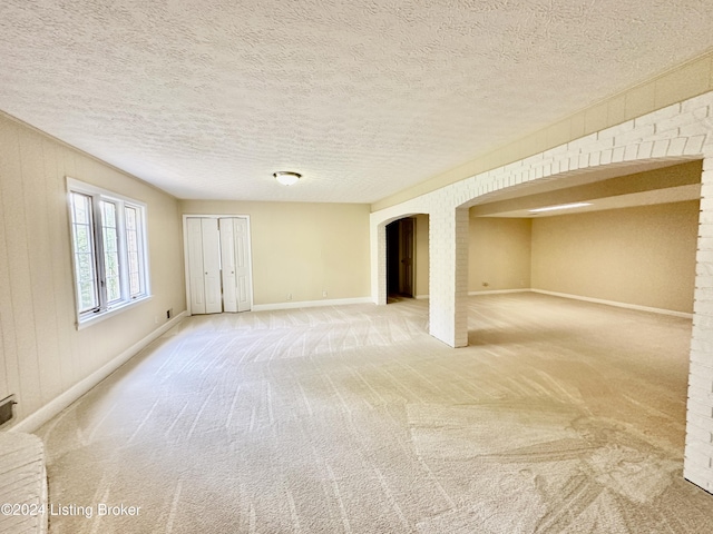 carpeted empty room featuring a textured ceiling