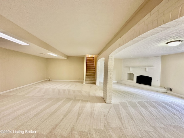 basement featuring a fireplace, a textured ceiling, and light carpet