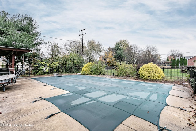 view of pool with a patio and a diving board