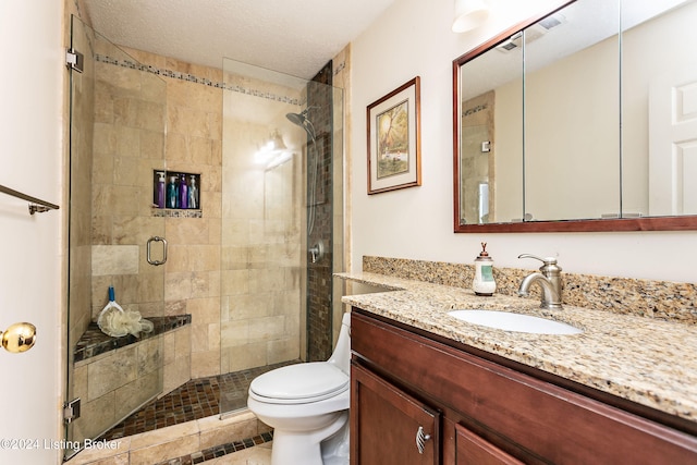 bathroom with walk in shower, a textured ceiling, vanity, tile patterned floors, and toilet