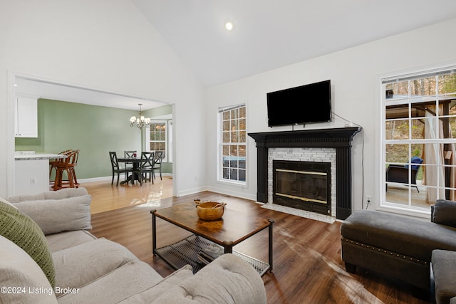 living room with high vaulted ceiling, a chandelier, and dark hardwood / wood-style floors