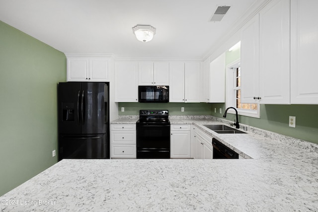 kitchen featuring white cabinets, light stone countertops, sink, and black appliances