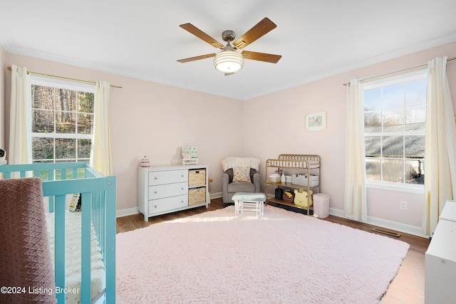 bedroom with hardwood / wood-style floors, ceiling fan, and crown molding