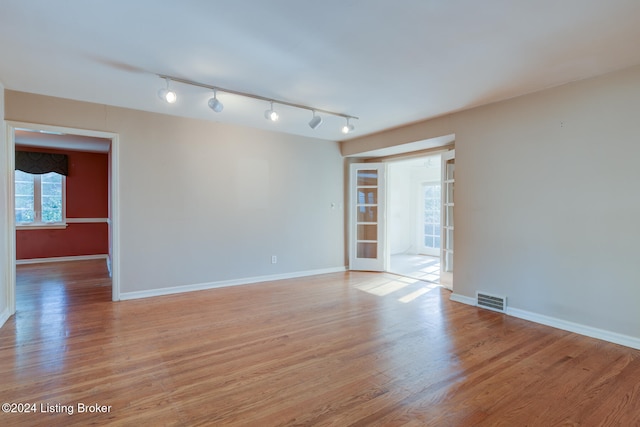 spare room featuring light wood-type flooring and rail lighting