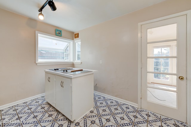 kitchen featuring white gas stovetop, rail lighting, and white cabinets