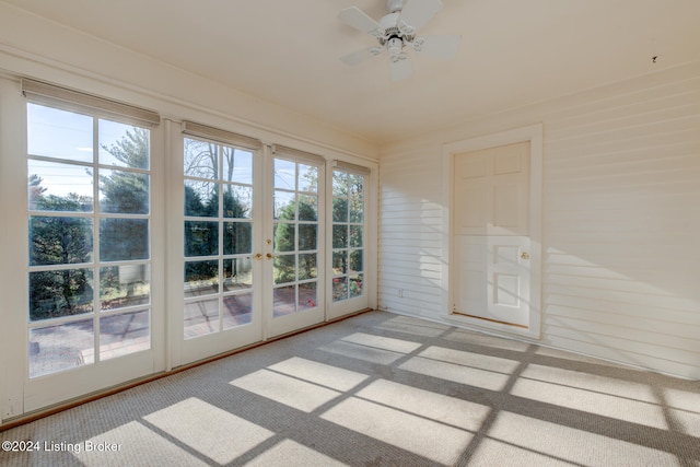 unfurnished sunroom with ceiling fan, plenty of natural light, and french doors