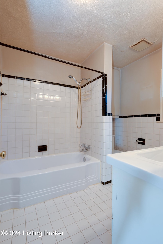 bathroom featuring tile walls, tile patterned flooring, and a textured ceiling