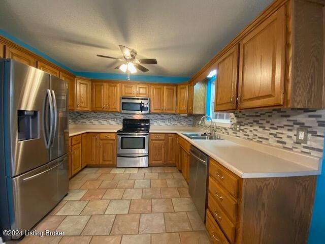 kitchen with ceiling fan, sink, appliances with stainless steel finishes, and tasteful backsplash