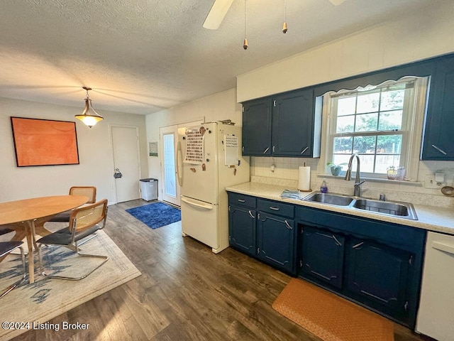 kitchen featuring sink, hanging light fixtures, white appliances, dark wood-type flooring, and decorative backsplash