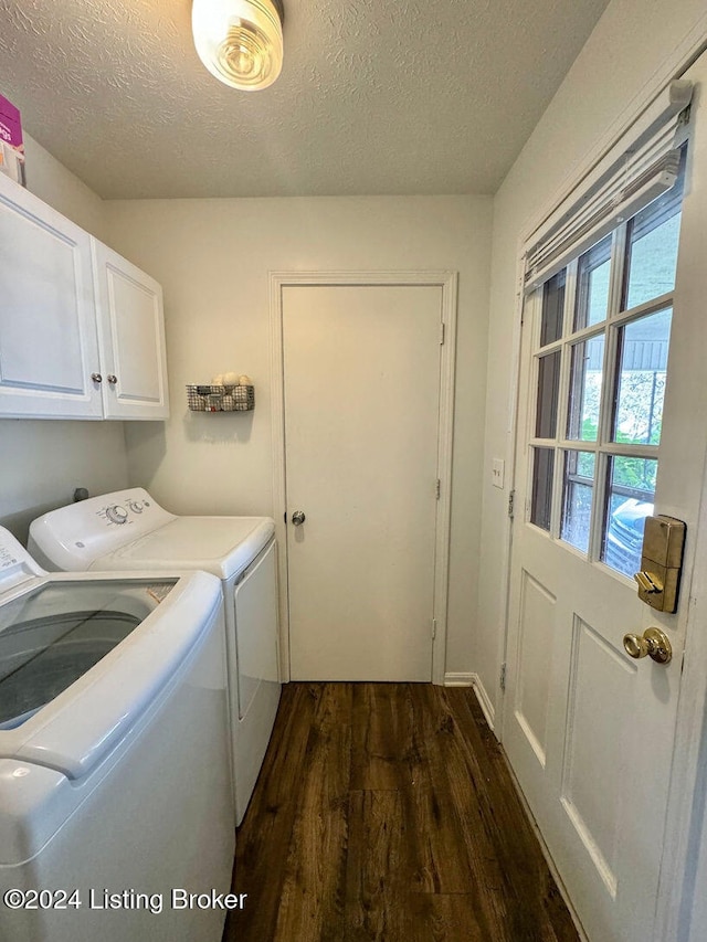 laundry area featuring dark hardwood / wood-style flooring, cabinets, plenty of natural light, a textured ceiling, and washer and clothes dryer