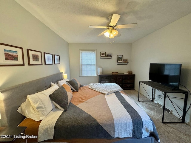 carpeted bedroom with ceiling fan and a textured ceiling