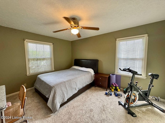 carpeted bedroom with a textured ceiling and ceiling fan