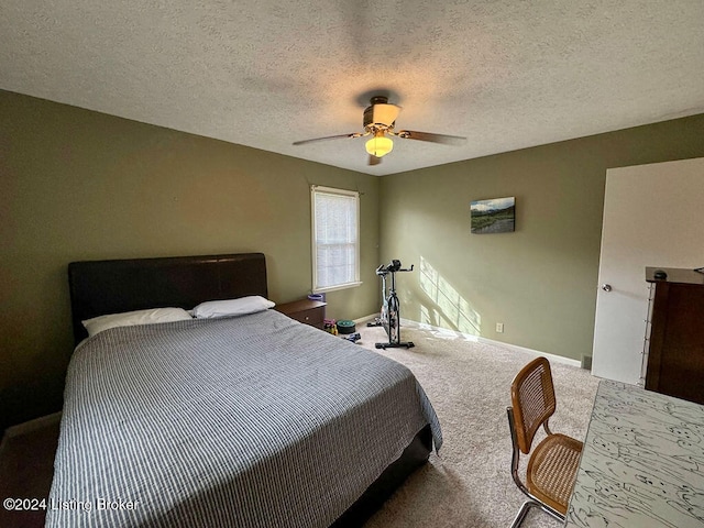 carpeted bedroom featuring a textured ceiling and ceiling fan