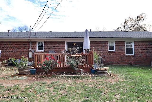 back of property with a lawn and a wooden deck