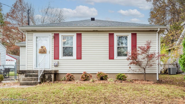 view of front of home with central AC unit and a front lawn