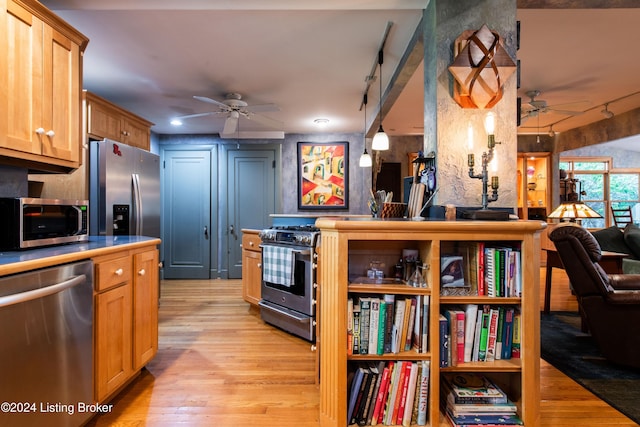 kitchen featuring stainless steel appliances, light hardwood / wood-style floors, track lighting, ceiling fan, and decorative light fixtures