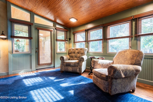 living area featuring a wealth of natural light, wood-type flooring, lofted ceiling, and wood ceiling