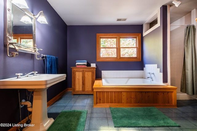 bathroom with tile patterned floors and a bathtub