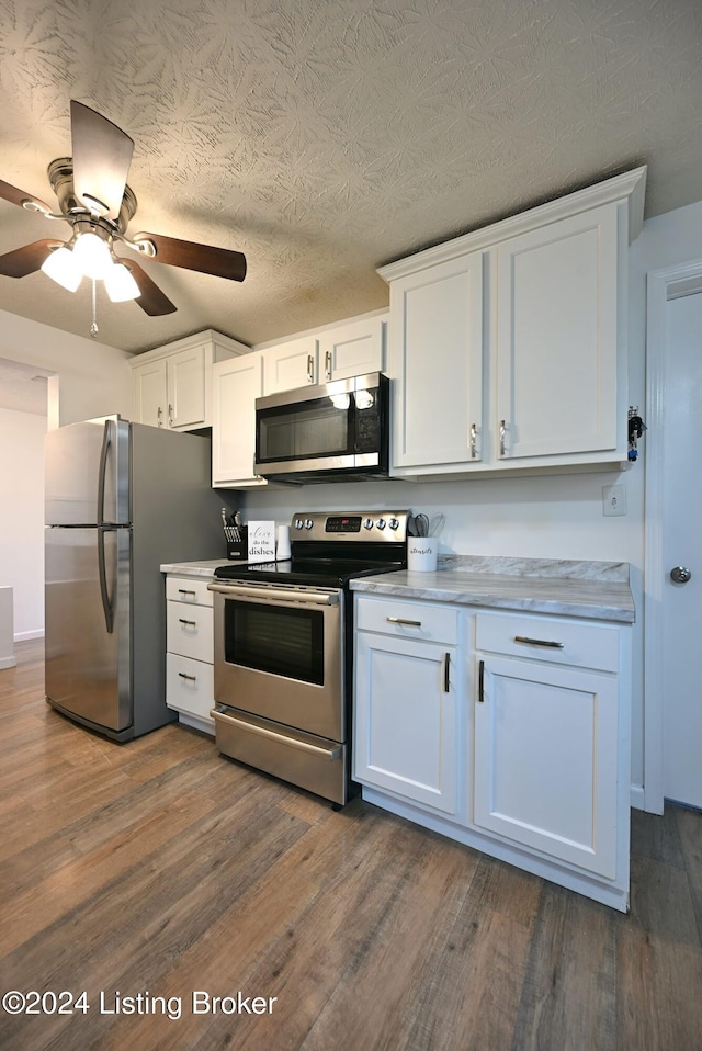 kitchen with white cabinetry, ceiling fan, dark hardwood / wood-style floors, and stainless steel appliances