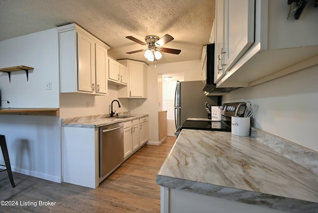 kitchen with white cabinetry, a textured ceiling, sink, light hardwood / wood-style floors, and dishwasher