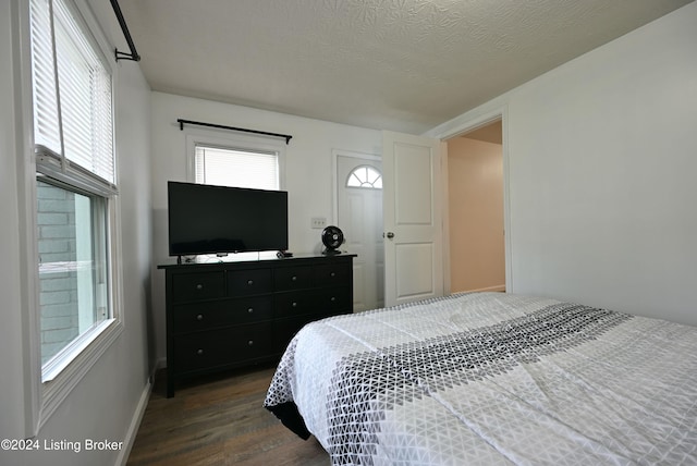 bedroom featuring a textured ceiling and dark hardwood / wood-style floors