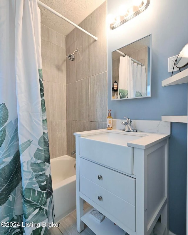 bathroom with shower / tub combo with curtain, vanity, and a textured ceiling