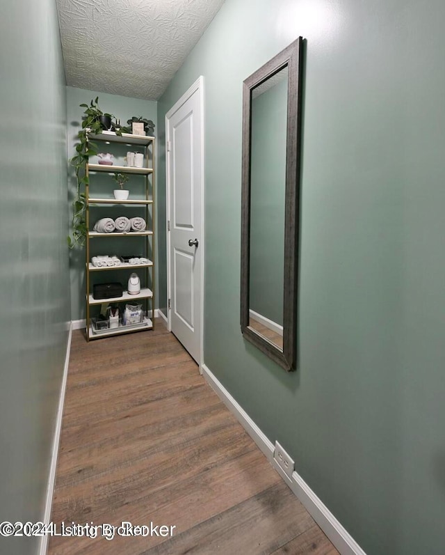 hall with a textured ceiling and dark hardwood / wood-style flooring