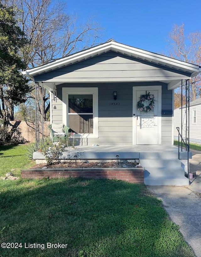 view of front of home featuring covered porch and a front yard