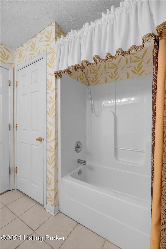 bathroom featuring shower / bathing tub combination, a textured ceiling, and tile patterned floors