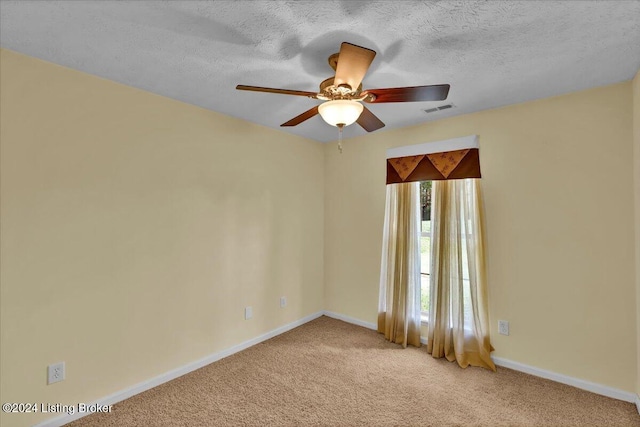 unfurnished room with ceiling fan, light colored carpet, and a textured ceiling