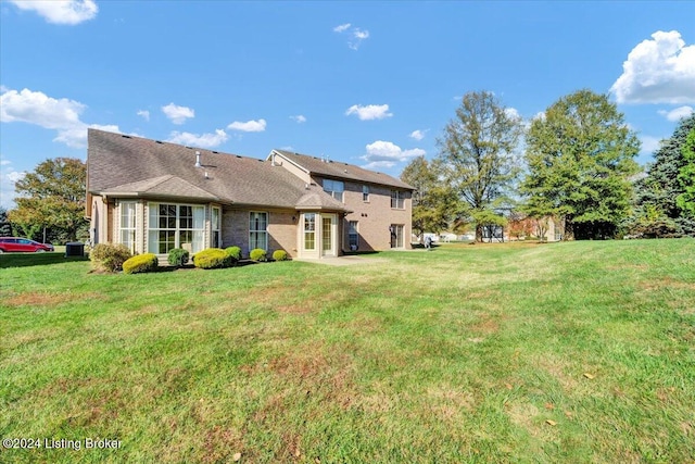 back of house with a lawn and cooling unit