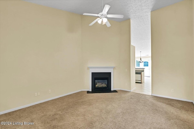 unfurnished living room with ceiling fan with notable chandelier and light colored carpet