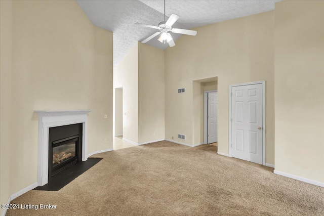 unfurnished living room featuring high vaulted ceiling, carpet, a textured ceiling, and ceiling fan