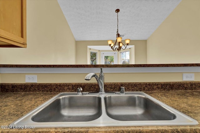 interior details with sink, decorative light fixtures, a textured ceiling, and a notable chandelier