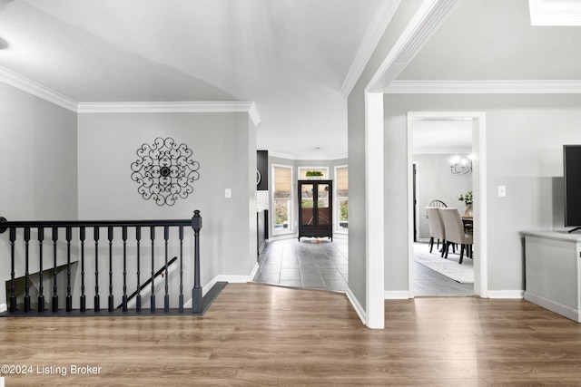 hall featuring hardwood / wood-style floors, a textured ceiling, an inviting chandelier, and crown molding