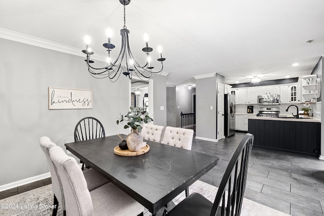 dining area featuring sink, crown molding, and an inviting chandelier