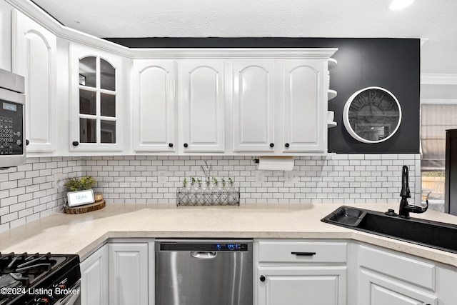 kitchen with white cabinets, decorative backsplash, stainless steel appliances, and sink