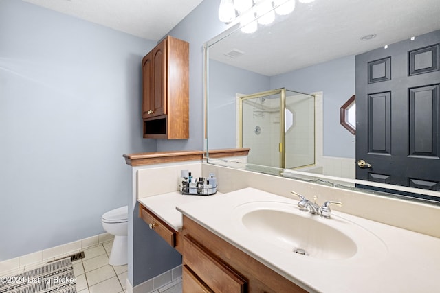 bathroom with tile patterned flooring, vanity, toilet, and walk in shower