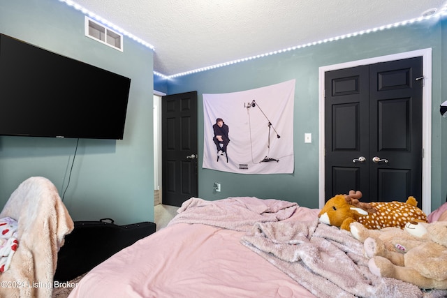 bedroom with carpet, a textured ceiling, and a closet