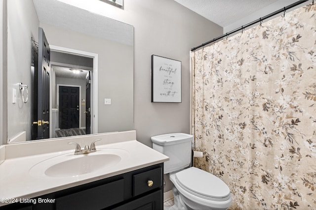 bathroom with vanity, a textured ceiling, toilet, and curtained shower