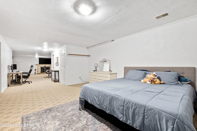 bedroom with light colored carpet, ornamental molding, and a textured ceiling