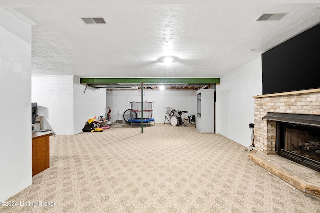 basement featuring a fireplace, carpet floors, and a textured ceiling