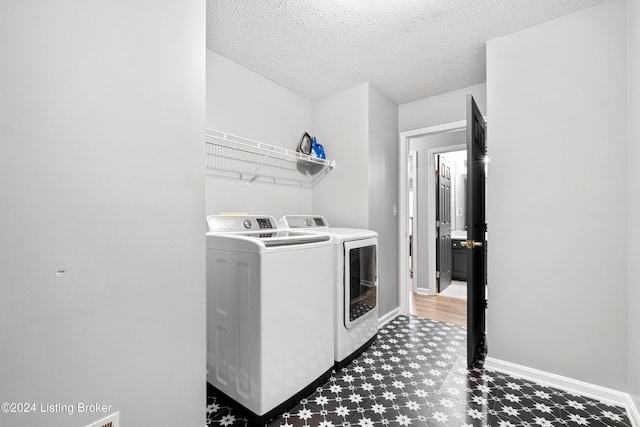 washroom featuring washer and dryer and a textured ceiling