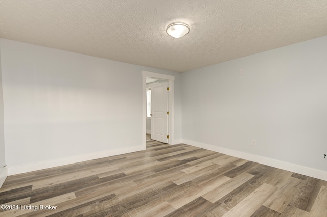 unfurnished room featuring hardwood / wood-style floors and a textured ceiling