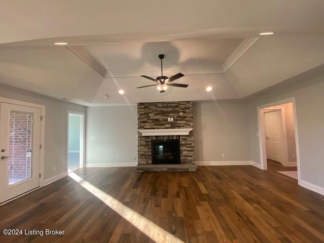 unfurnished living room featuring ornamental molding, a fireplace, dark wood-type flooring, and ceiling fan